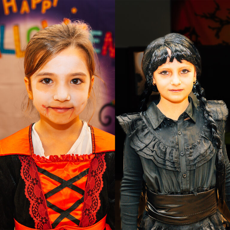 EIFA Two children in costumes. Left: a child in a red and black dress with face paint, set against a Happy Halloween backdrop at the bilingual EIFA School. Right: a child dressed in black with braided hair, possibly in a gothic style.