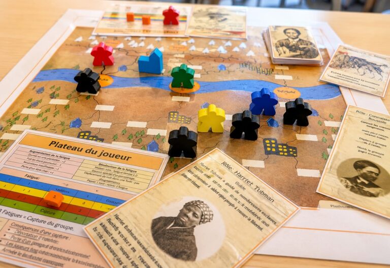 EIFA A board game featuring colorful player pieces, cards with historical figures, and a map with rivers and buildings—perfect for International Open Day. The cards and a chart are in French; one card shows a photo labeled Harriet Tubman.