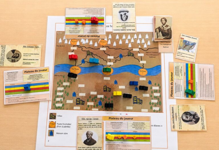 EIFA A board game setup on a table features a map with colored wooden pieces, player boards, and cards depicting historical figures, likely related to the Underground Railroad—perfect for engaging visitors during International Open Day.