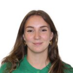 EIFA Une femme aux longs cheveux châtains, vêtue d'un gilet vert et portant des boucles d'oreilles en forme de cœur.
