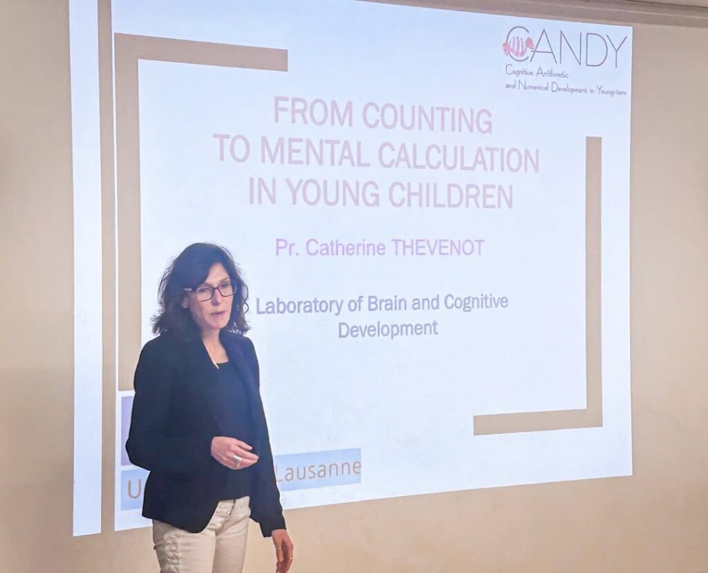 EIFA A woman stands in front of a projected presentation slide titled From Counting to Mental Calculation in Young Children by Pr. Catherine Thevenot, at the Laboratory of Brain and Cognitive Development.