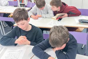 EIFA Un groupe de garçons assis à des pupitres dans une salle de classe. EIFA Un groupe de garçons assis à des pupitres dans une salle de classe.