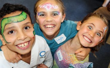 EIFA Trois enfants souriants, au visage peint de couleurs vives, posent ensemble pour célébrer la Journée mondiale de l’alimentation. L’un d’eux porte un uniforme d’arts martiaux, tandis que les autres portent des vêtements décontractés et des robes, leurs badges étant visibles alors qu’ils rayonnent d’excitation. EIFA Trois enfants souriants, au visage peint de couleurs vives, posent ensemble pour célébrer la Journée mondiale de l'alimentation. L'un d'eux porte un uniforme d'arts martiaux, tandis que les autres portent des vêtements décontractés et des robes, leurs badges étant visibles alors qu'ils rayonnent d'excitation.