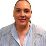 EIFA A woman wearing a light blue button-down shirt with lace paneling.