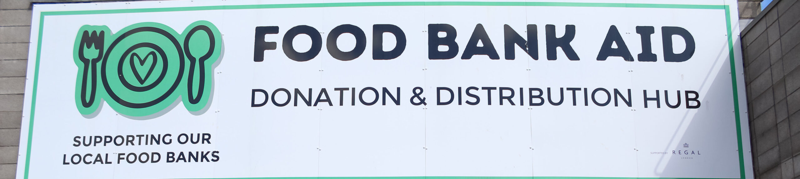 EIFA A large sign reads Food Bank Aid Donation & Distribution Hub with a green plate, fork, and spoon icon. Below, it says Supporting our local food banks—just as EIFA Pupils Explore the London Wetland Centre and support our community.