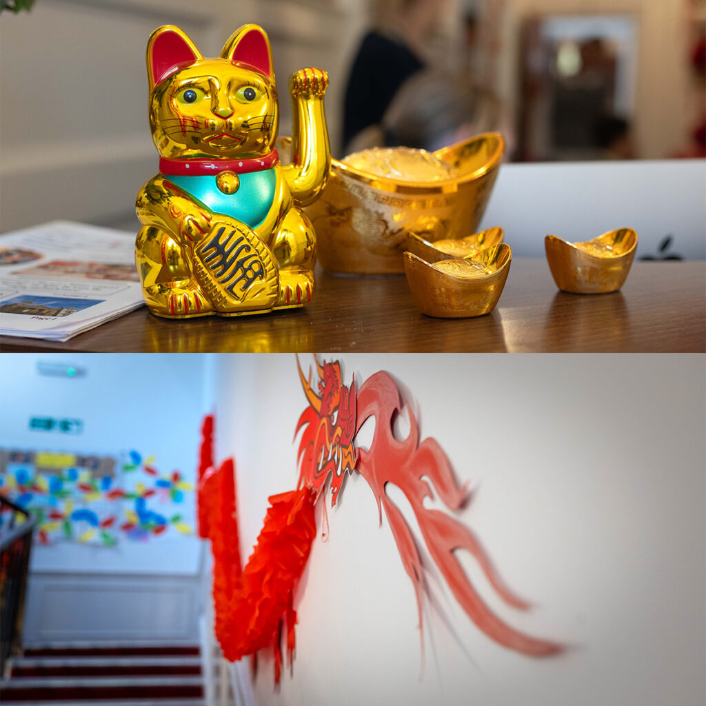 EIFA En haut : une figurine de chat doré ondulant (Maneki-neko) et des lingots dor sur une table. En bas : un dragon rouge décoratif sur un mur blanc à côté de fleurs en papier rouge près dun escalier.