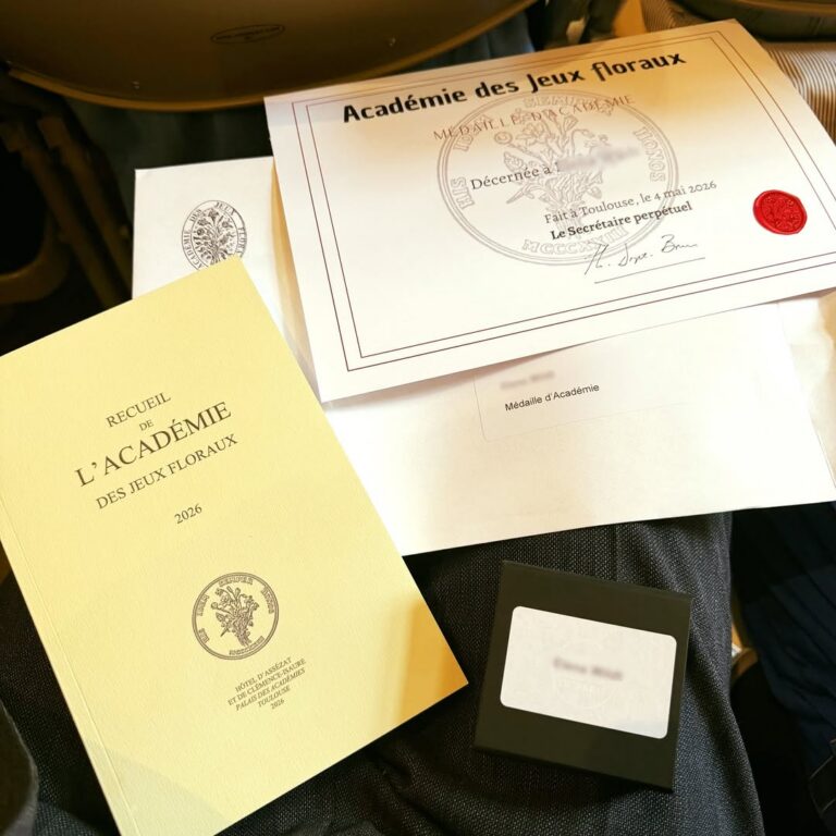 EIFA A certificate, a sealed envelope, a yellow booklet titled Recueil de l’Académie des Jeux Floraux 2024, and a small black box are displayed on someone's lap at the International Open Day event.