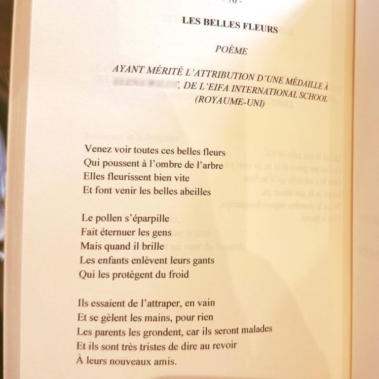 EIFA A photo of a book page displaying a French poem titled Les Belles Fleurs, about beautiful flowers and bees, with the heading mentioning an award from LEIFA International School (UK) on International Open Day. The text is clearly visible and legible.