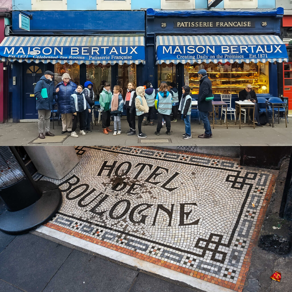 EIFA Un groupe de personnes attend devant la Maison Bertaux, une pâtisserie à la façade bleue. Une mosaïque au sol indique « HOTEL DE BOULOGNE ». La pâtisserie dispose de places assises en extérieur et les clients profitent de leur moment de détente.